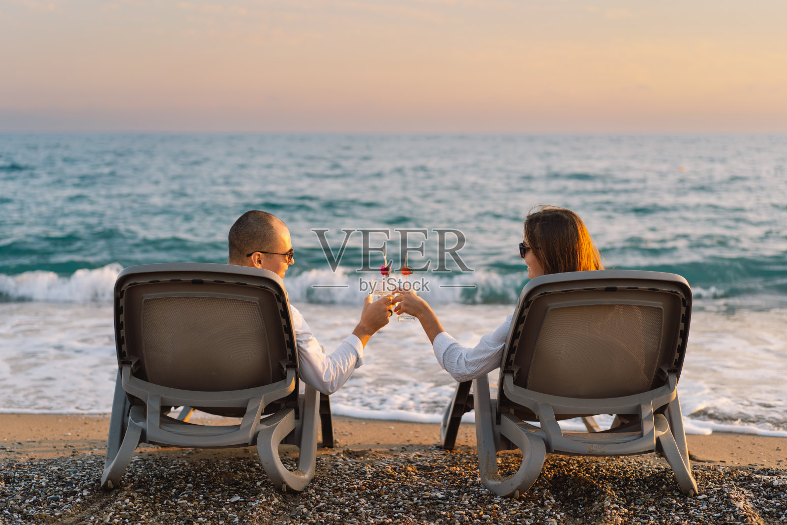 搭配清爽的鸡尾酒，在沙滩的躺椅上放松照片摄影图片