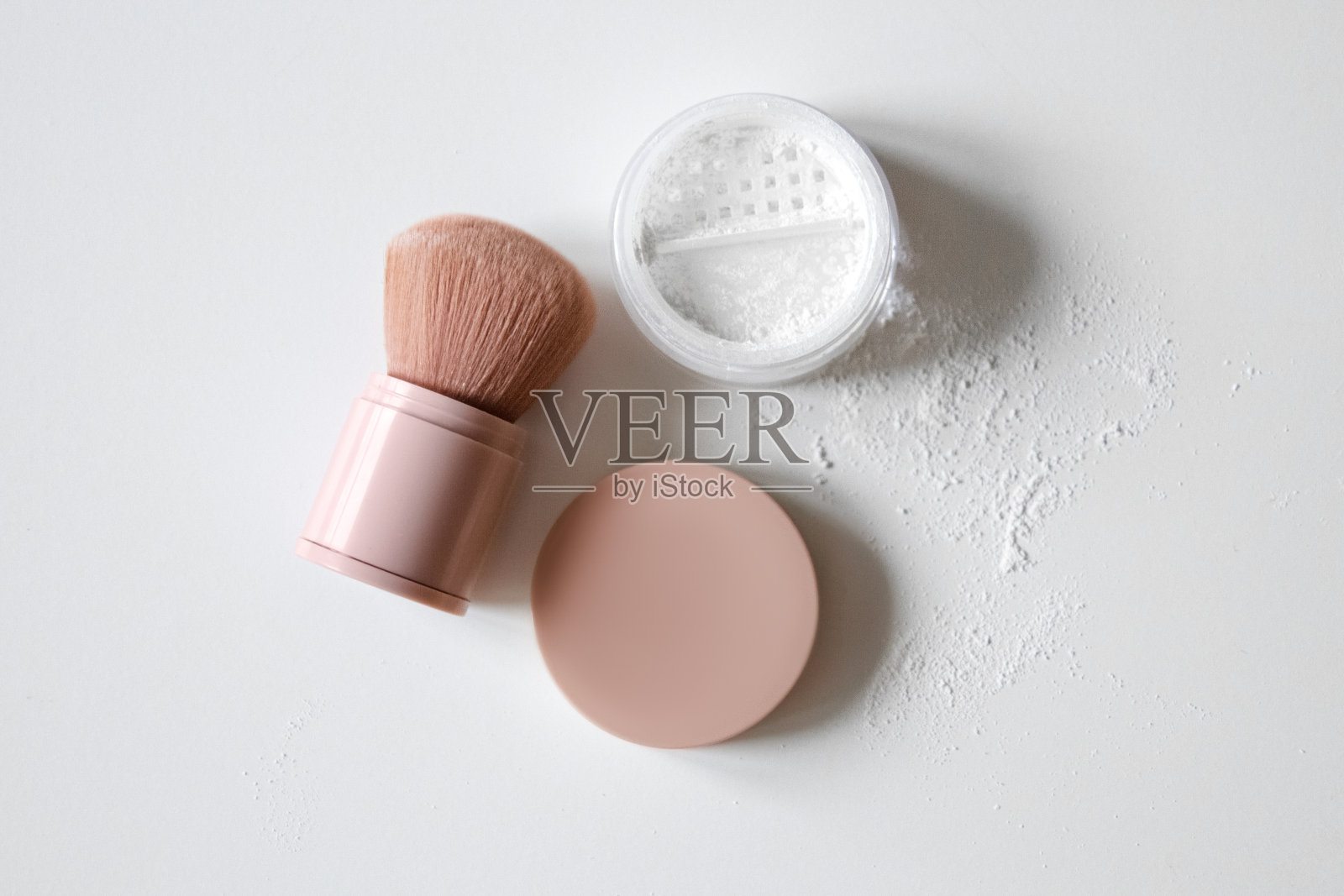 粉底，化妆刷在浅色的背景上。散粉。照片摄影图片