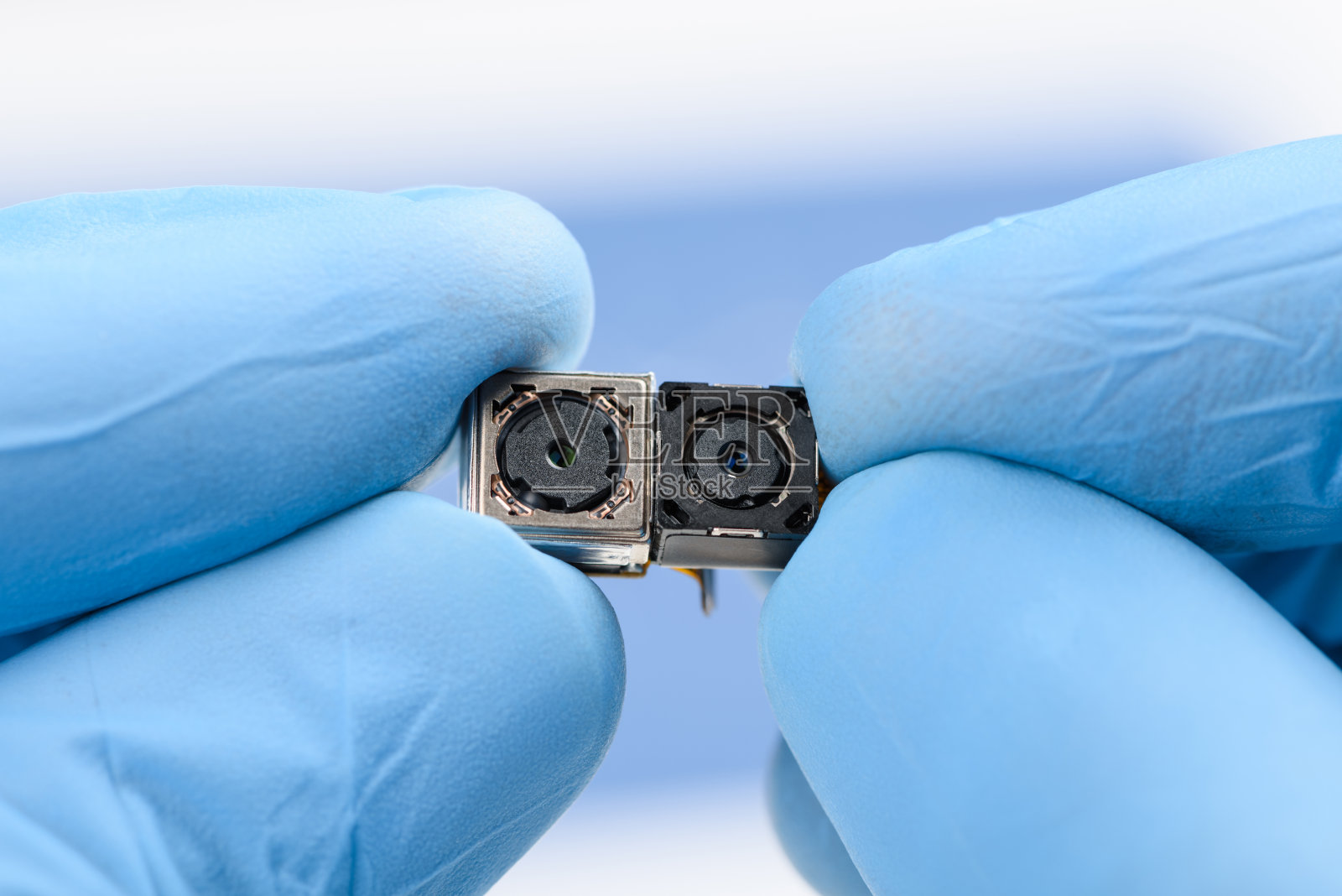 两个小相机模块在科学家的手中。智能手机传感器技术研究照片摄影图片