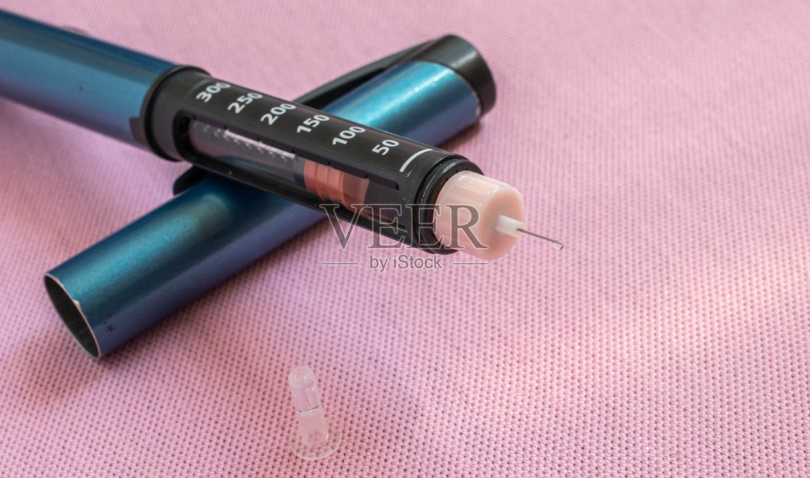 胰岛素笔注射器，粉色背景上装有针头的胰岛素笔，糖尿病日照片摄影图片