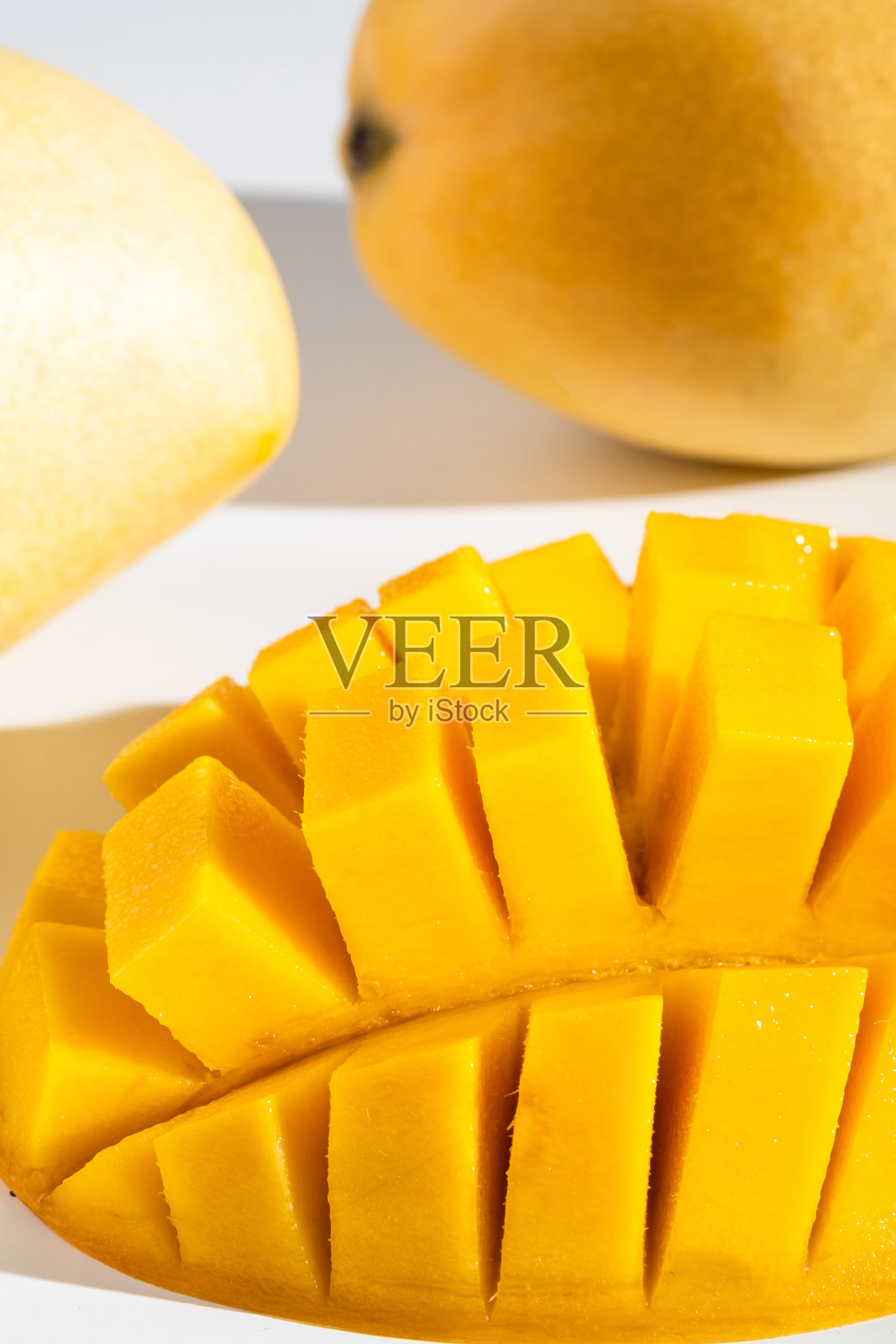 白色底色，成熟多汁的泰国芒果。棕榈树上坚硬的光影。照片摄影图片