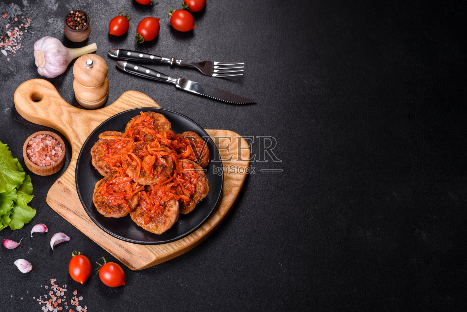 黑色盘子里是肉丸配番茄酱和香草照片摄影图片