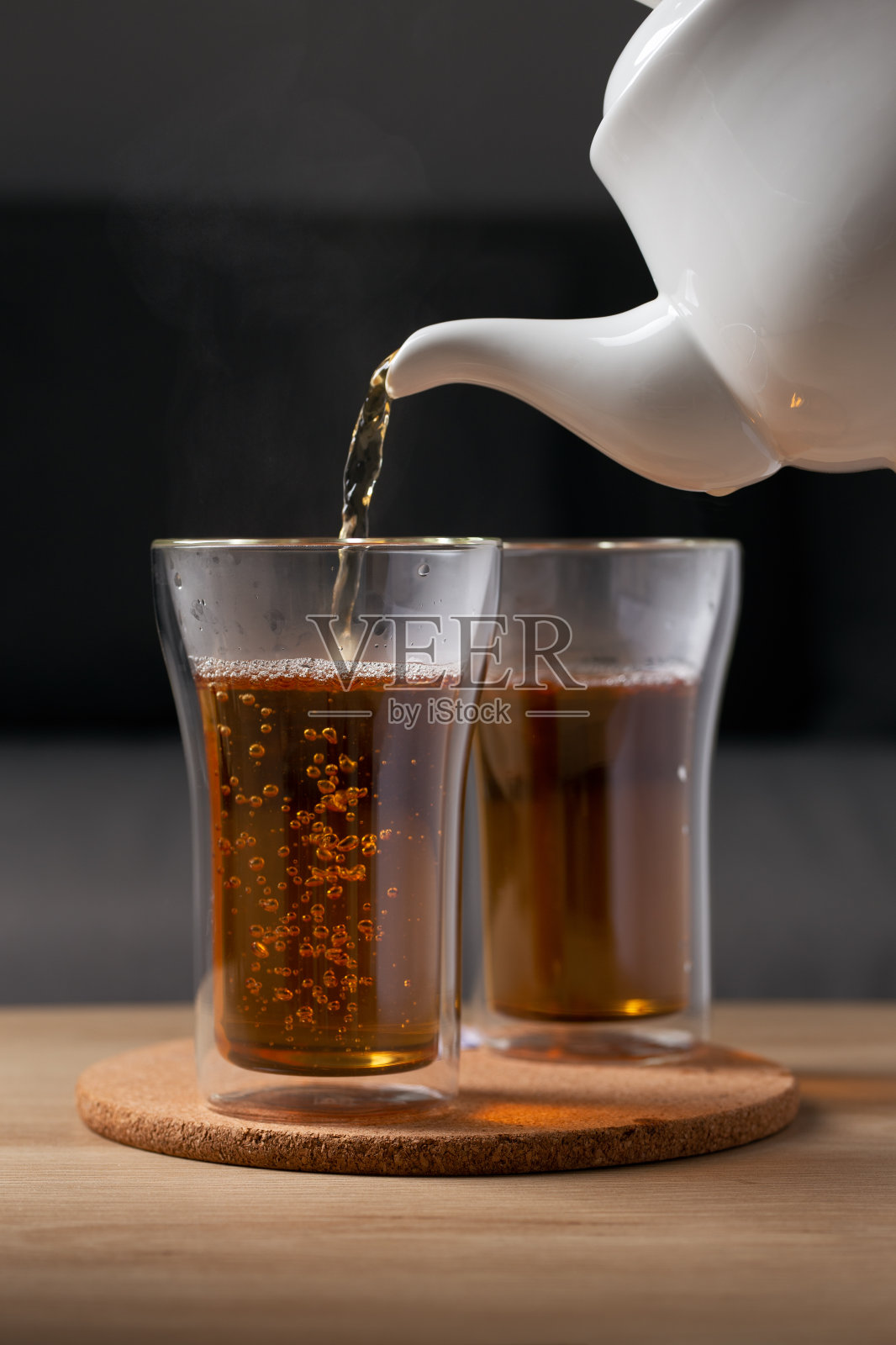 将热茶倒入玻璃杯中照片摄影图片