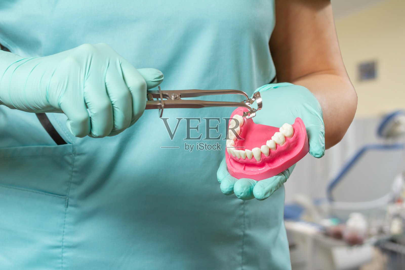 戴手套的牙医使用橡皮障夹钳照片摄影图片