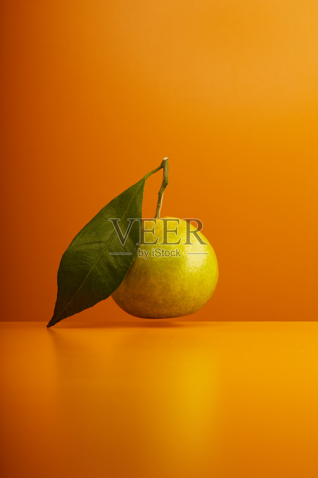橘红色的水果，叶子悬浮在橘色的背景上照片摄影图片