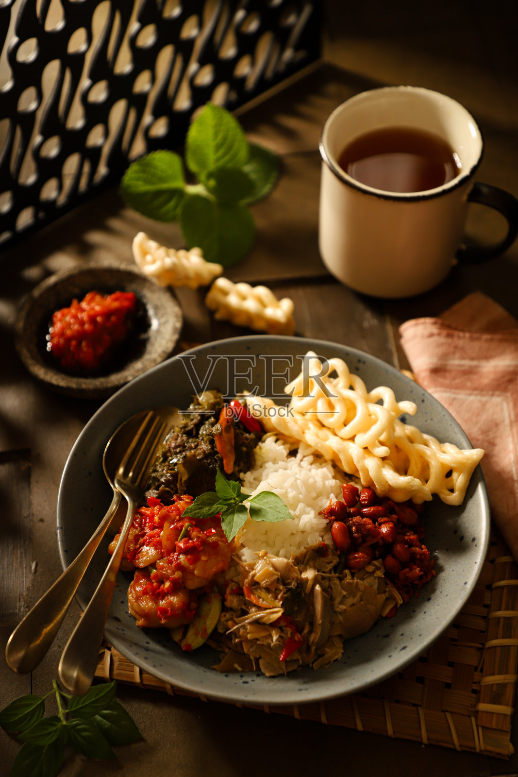Nasi Campur，印尼饭肉，海鲜和蔬菜配菜和饼干照片摄影图片