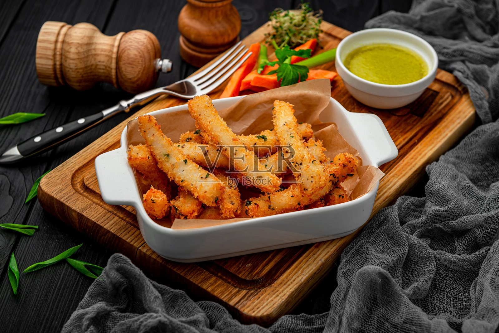 鱼条和新鲜蔬菜放在木板上。照片摄影图片