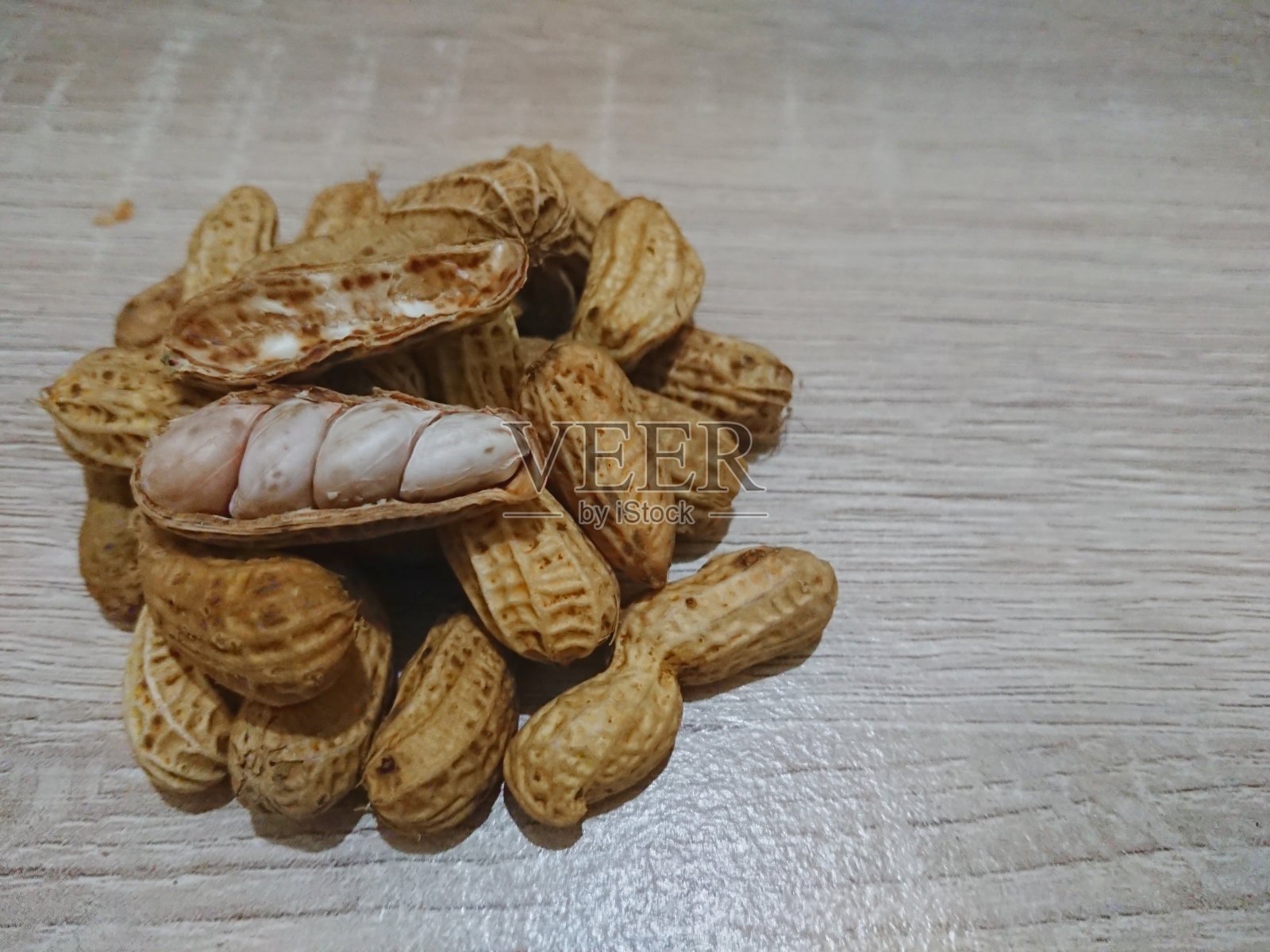 木头背景上的花生壳照片摄影图片