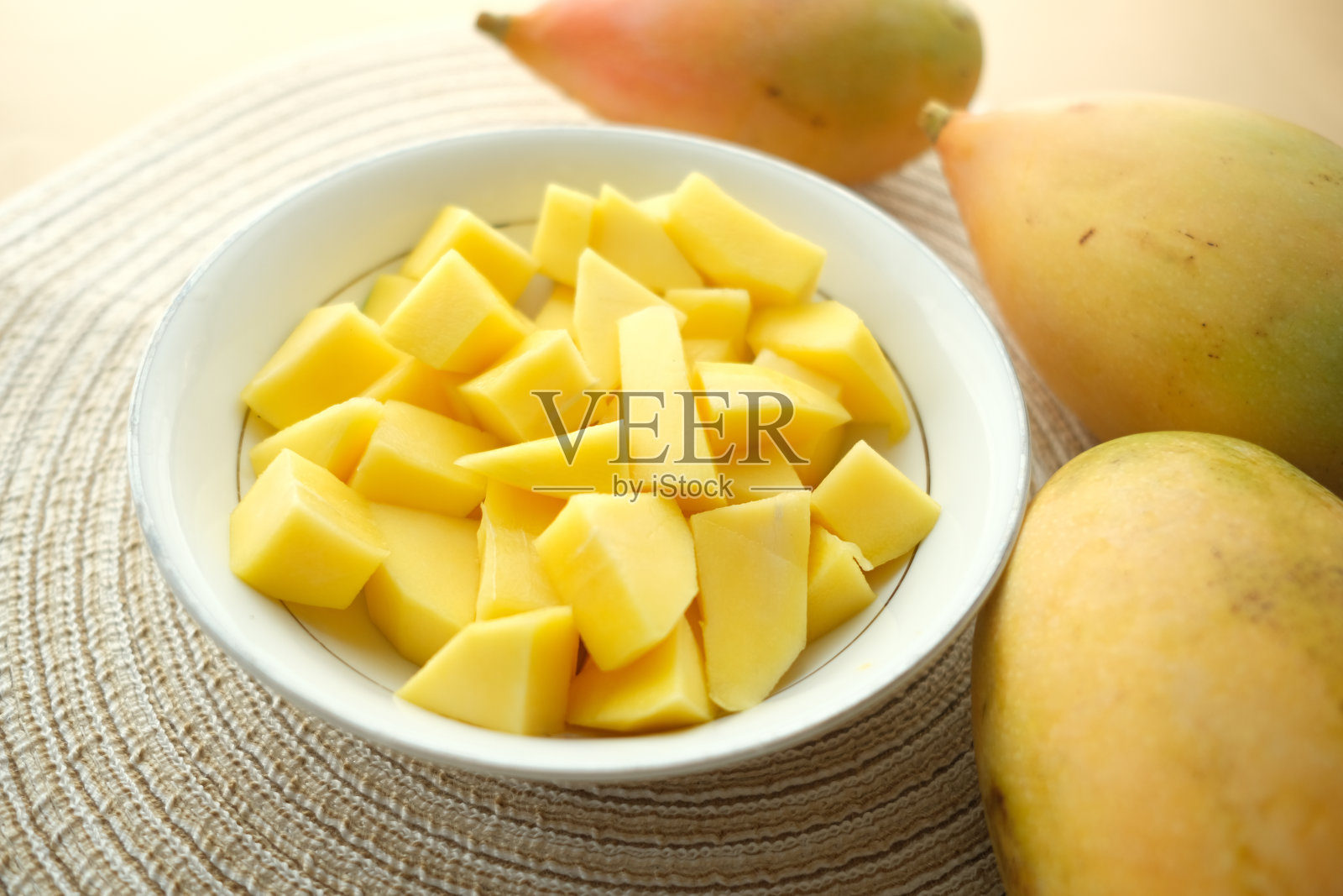 把成熟的芒果切成黄色，自上而下放在碗里照片摄影图片