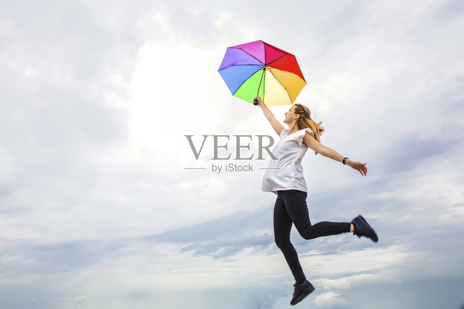 彩色的伞载着一个女人飞向天空照片摄影图片