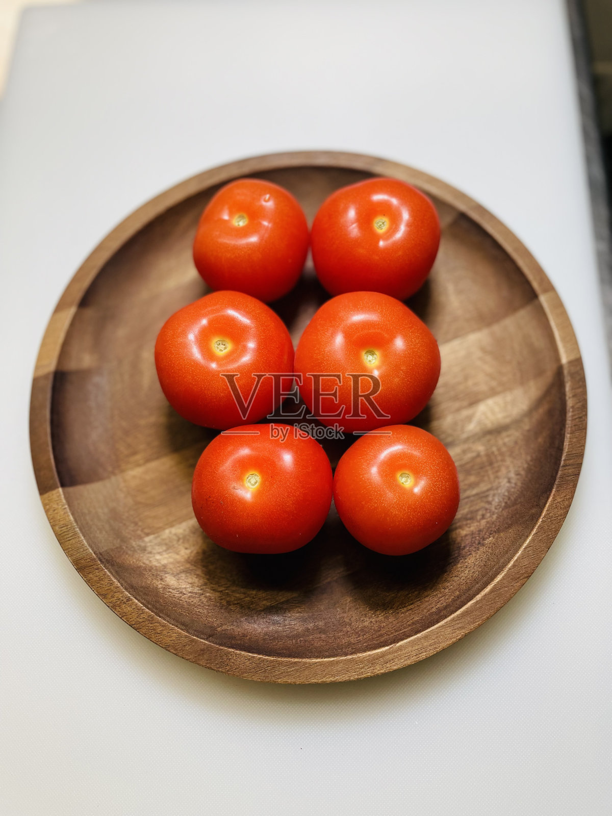 西红柿放在木盘子里照片摄影图片