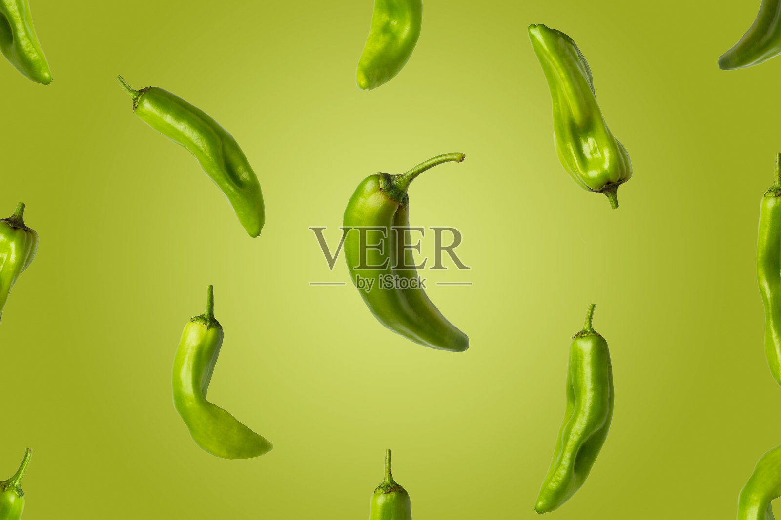 绿色背景上青椒飞舞的创意图像。照片摄影图片