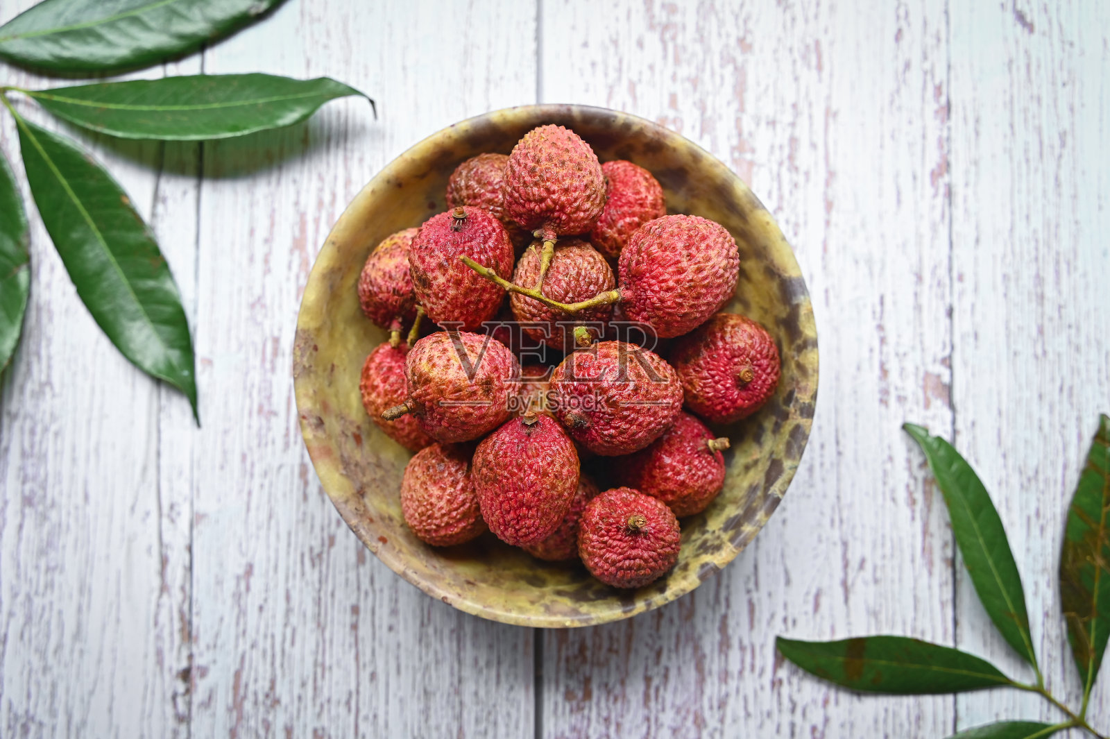 黑色背景的新鲜有机荔枝。荔枝在灰色的石头为背景。五颜六色的荔枝水果图案。平铺，俯视图，拷贝空间照片摄影图片