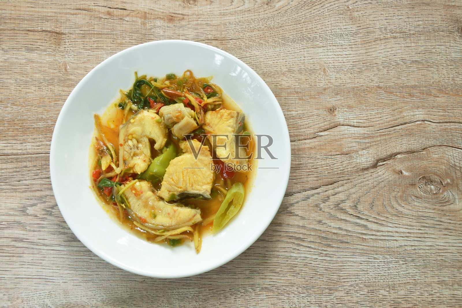 辛辣油炸亚洲红尾鲶配香草和辣椒照片摄影图片