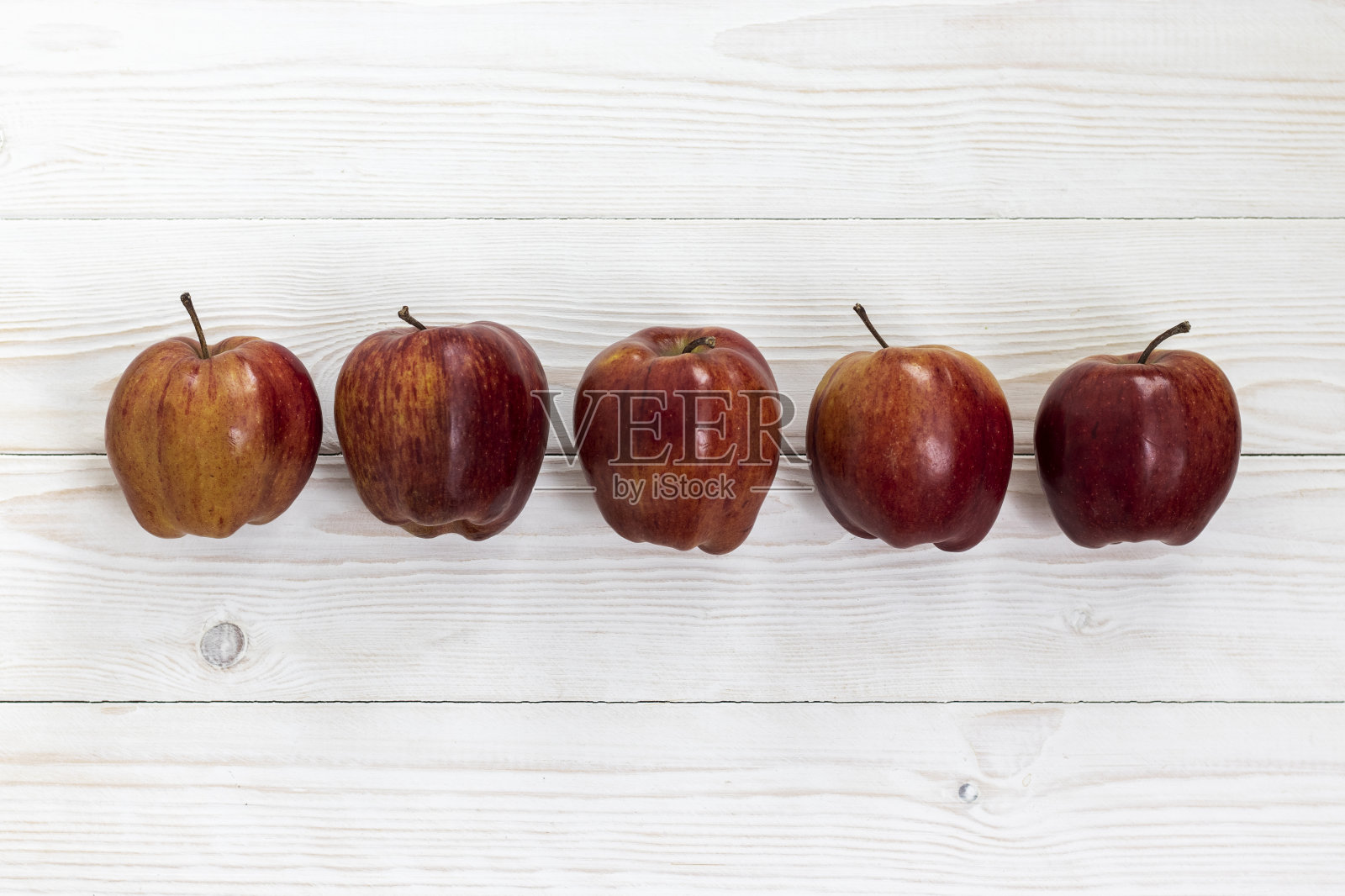 红苹果在木桌上。照片摄影图片