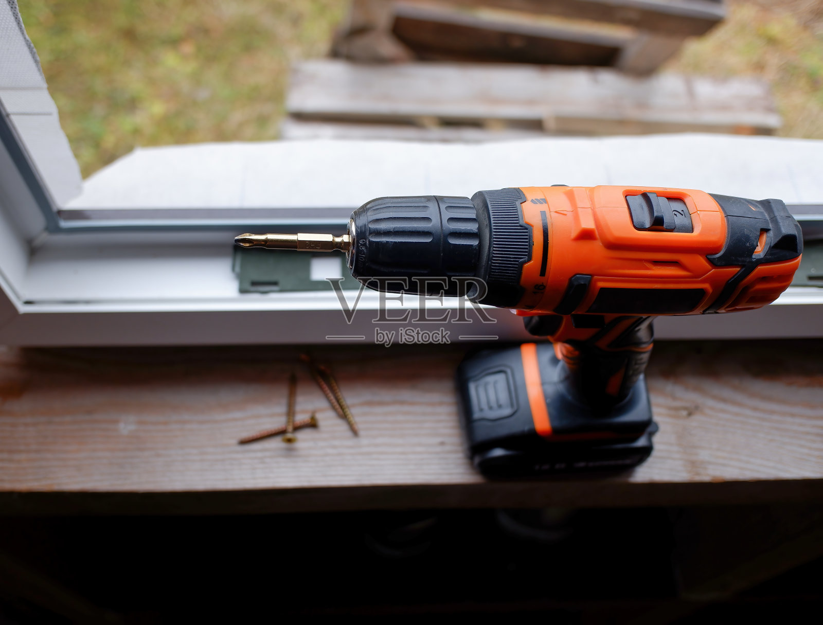 安装在塑料窗背景上的螺丝刀。照片摄影图片