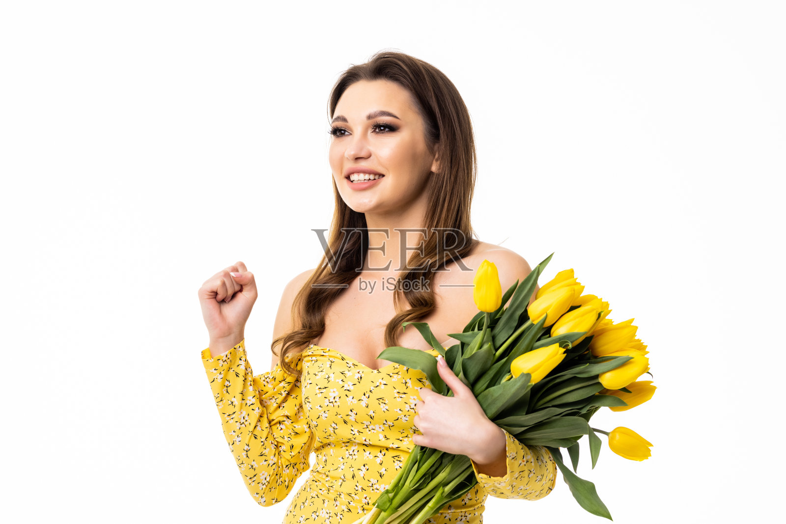 一个欢快的年轻女孩的肖像，穿着裙子，拿着黄色郁金香花束孤立在白色背景照片摄影图片