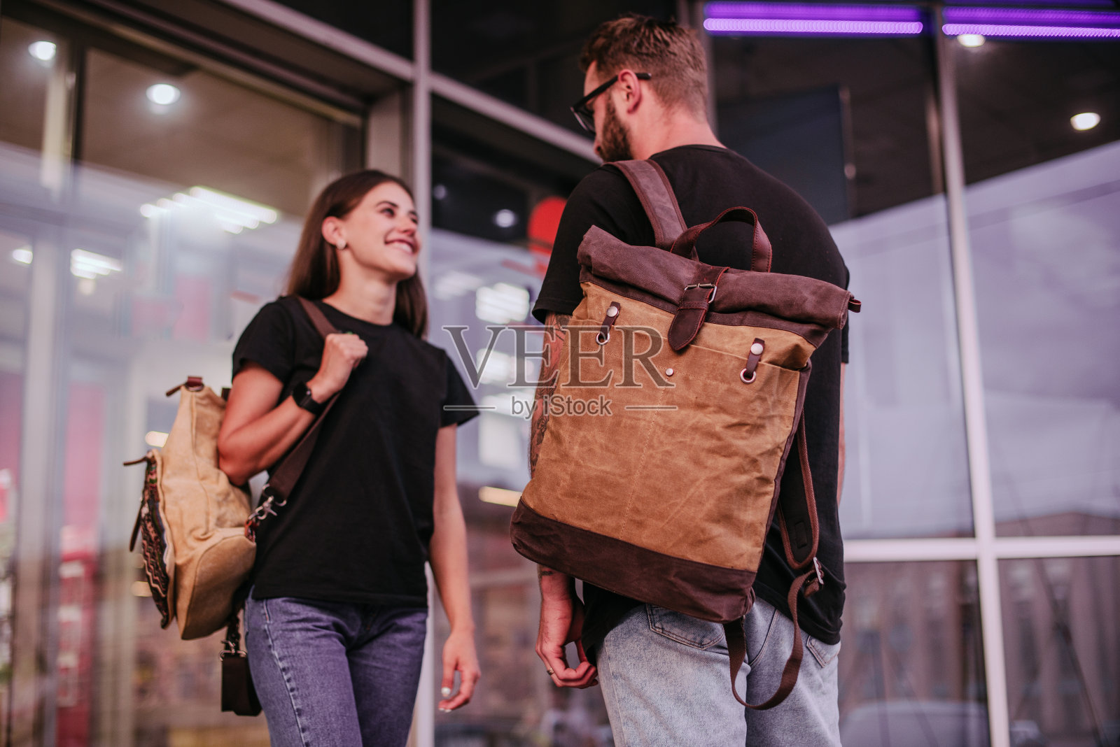 街上背着帆布背包的行人。侧视图。照片摄影图片