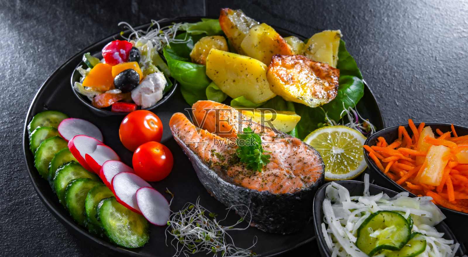 炸三文鱼配土豆和蔬菜沙拉照片摄影图片