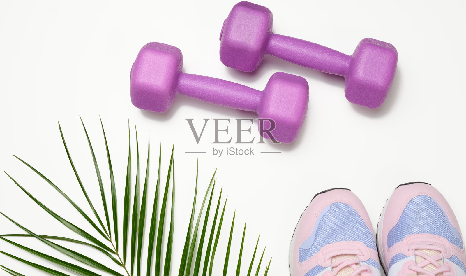 一双粉色运动鞋和白色背景的紫色哑铃照片摄影图片