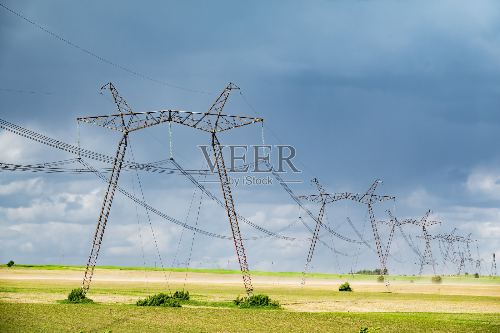 乌克兰田地里的一排排电线支撑着输电塔。照片摄影图片