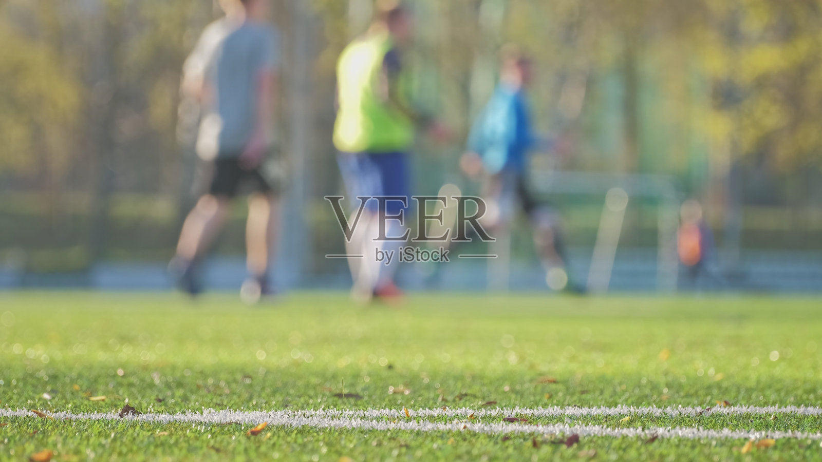 匿名男性足球运动员在训练期间在足球场上奔跑照片摄影图片