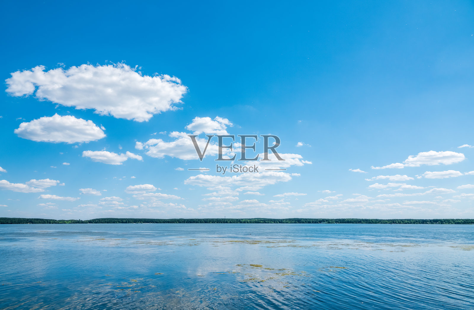 蓝色的湖水配上多云的天空，自然的背景。照片摄影图片