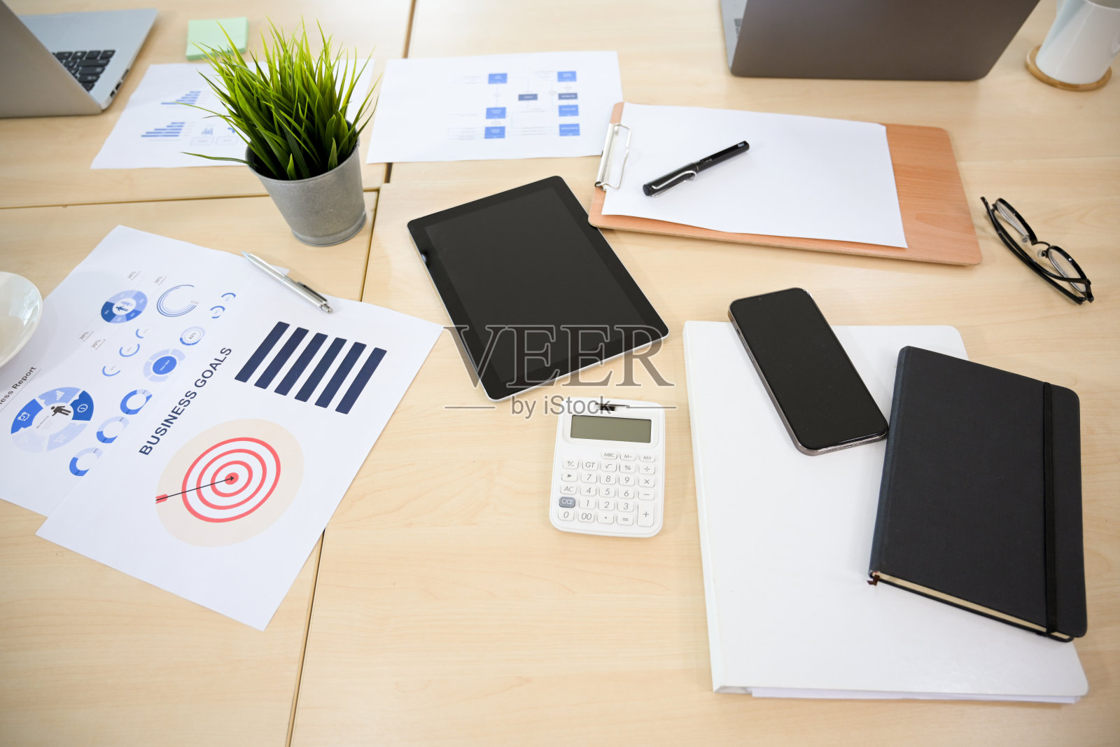 俯拍，堆满用品的办公桌凌乱不堪。照片摄影图片