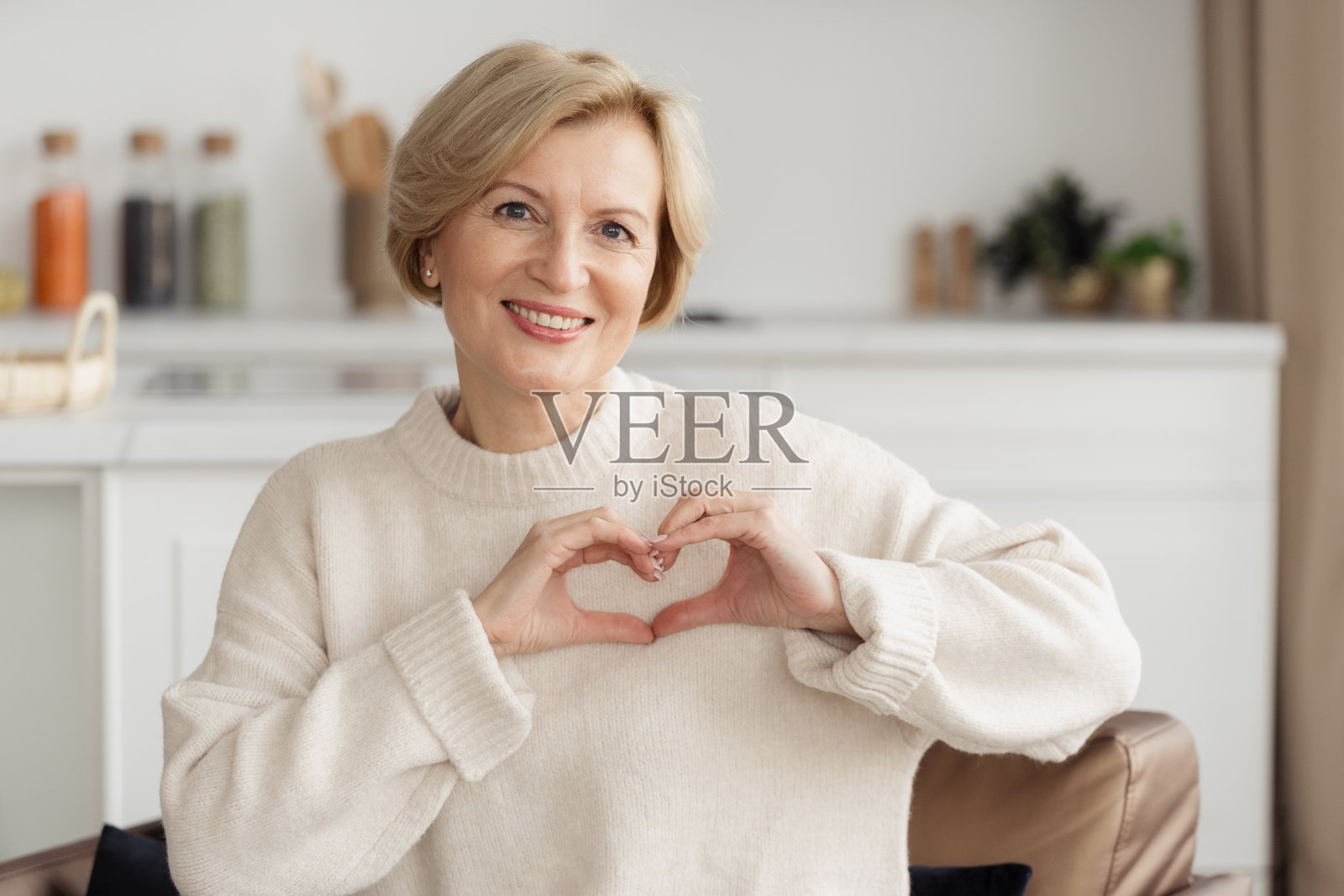 中年妇女做手势，比心照片摄影图片