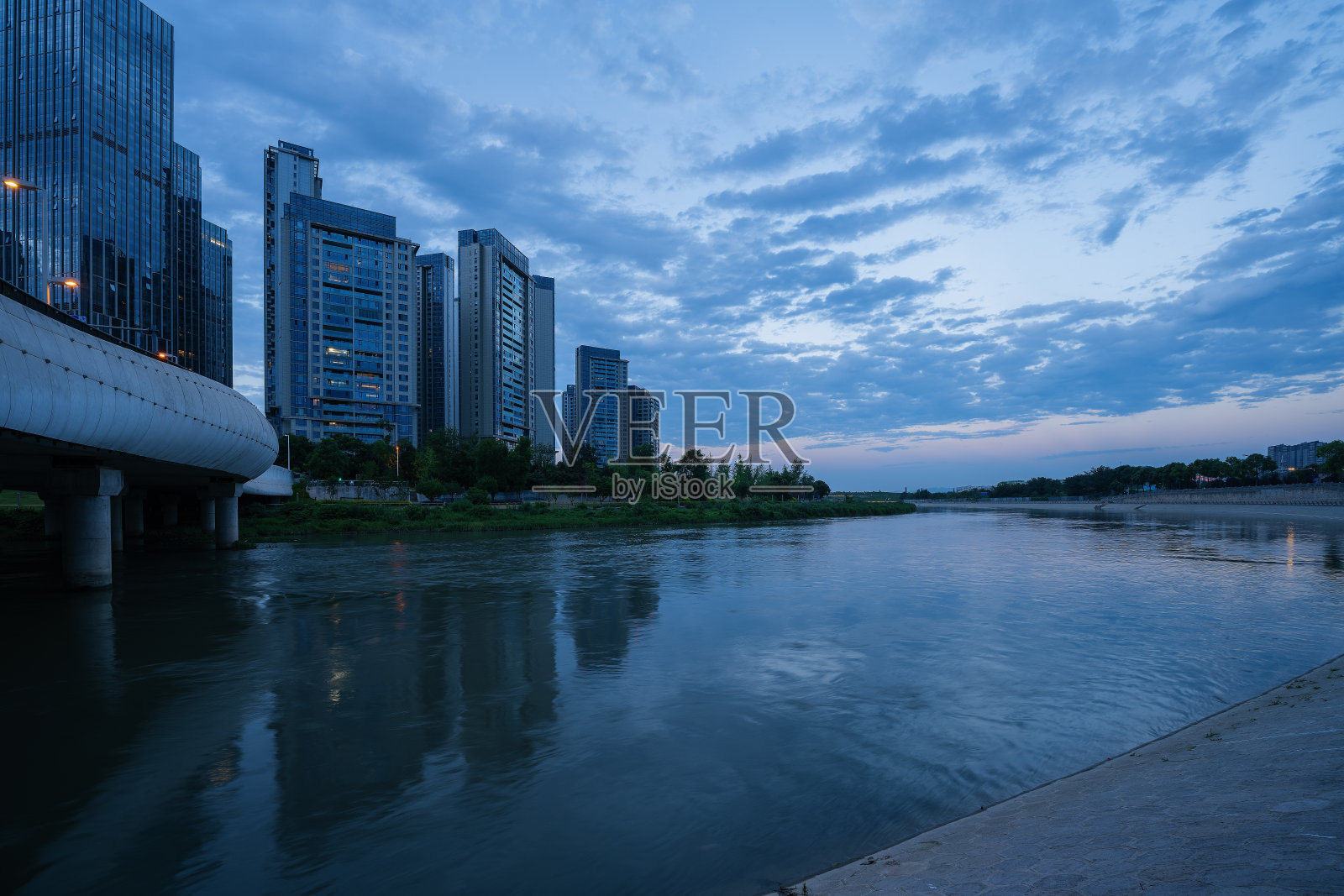 黄昏时分沿河的现代建筑和桥梁照片摄影图片