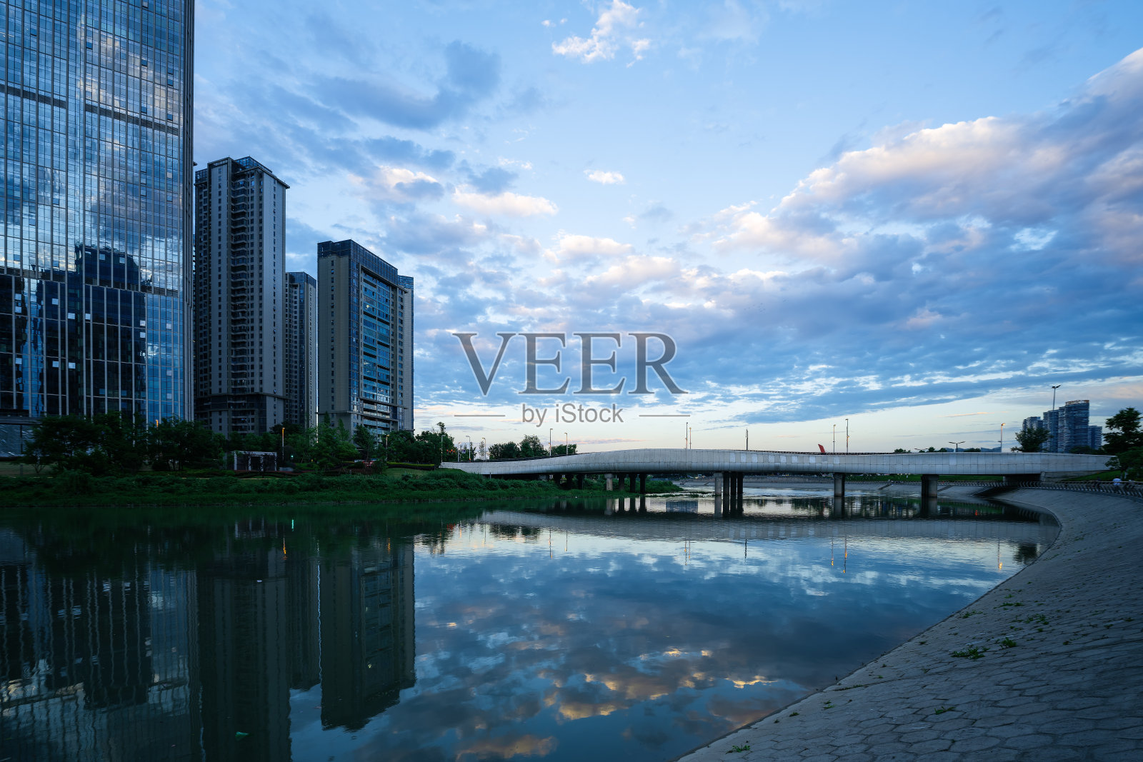 黄昏时分沿河的现代建筑和桥梁照片摄影图片