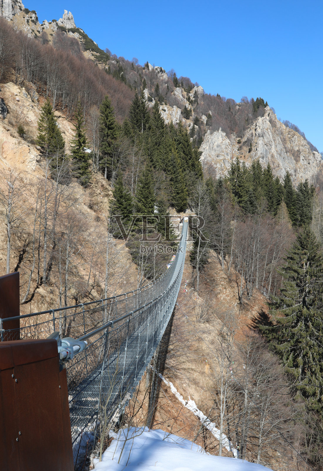 悬索桥悬吊在高山峡谷上空，由钢索支撑照片摄影图片