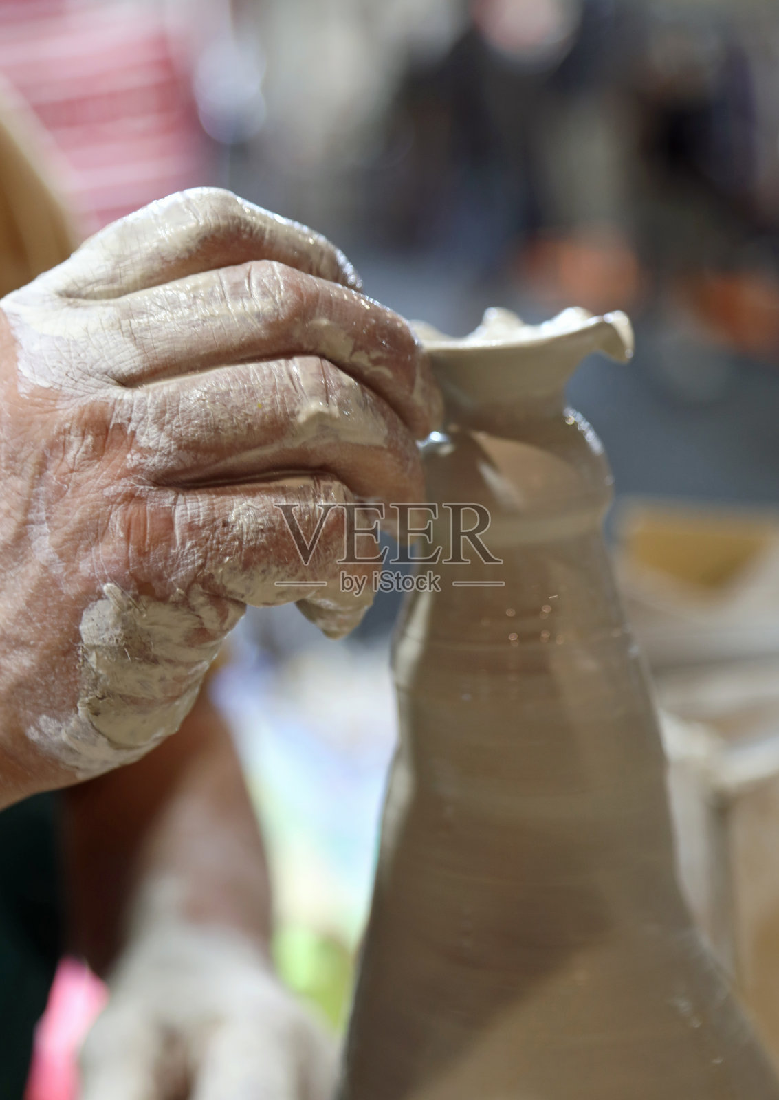 一位上了年纪的陶工在旋转的车床上制作陶罐时的手照片摄影图片