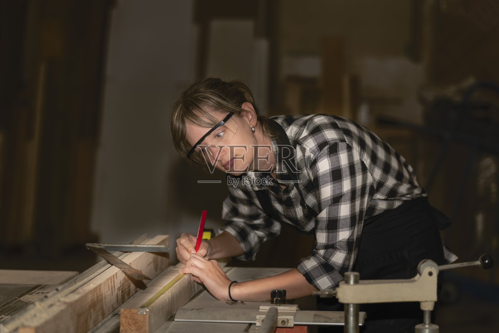 丈量木板的女木匠照片摄影图片