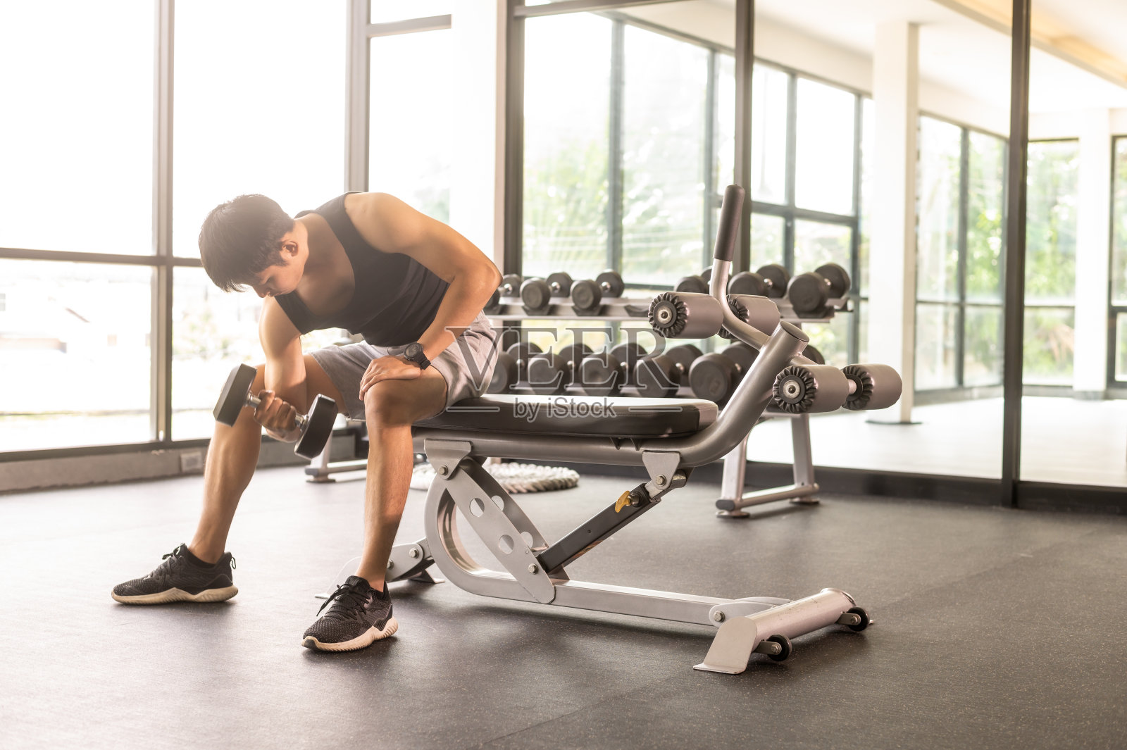 女子运动女孩运动后坐着休息，在健身喝水和运动器械前地面照片摄影图片