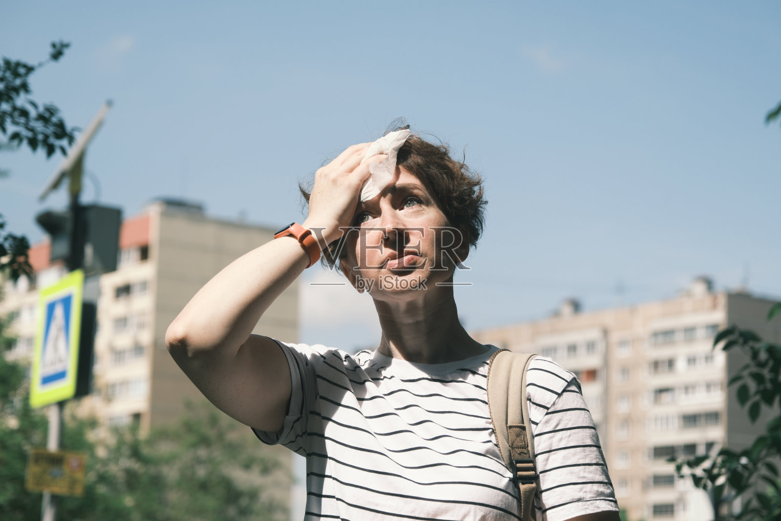 一位妇女在炎热的天气里擦干脸上的汗水照片摄影图片