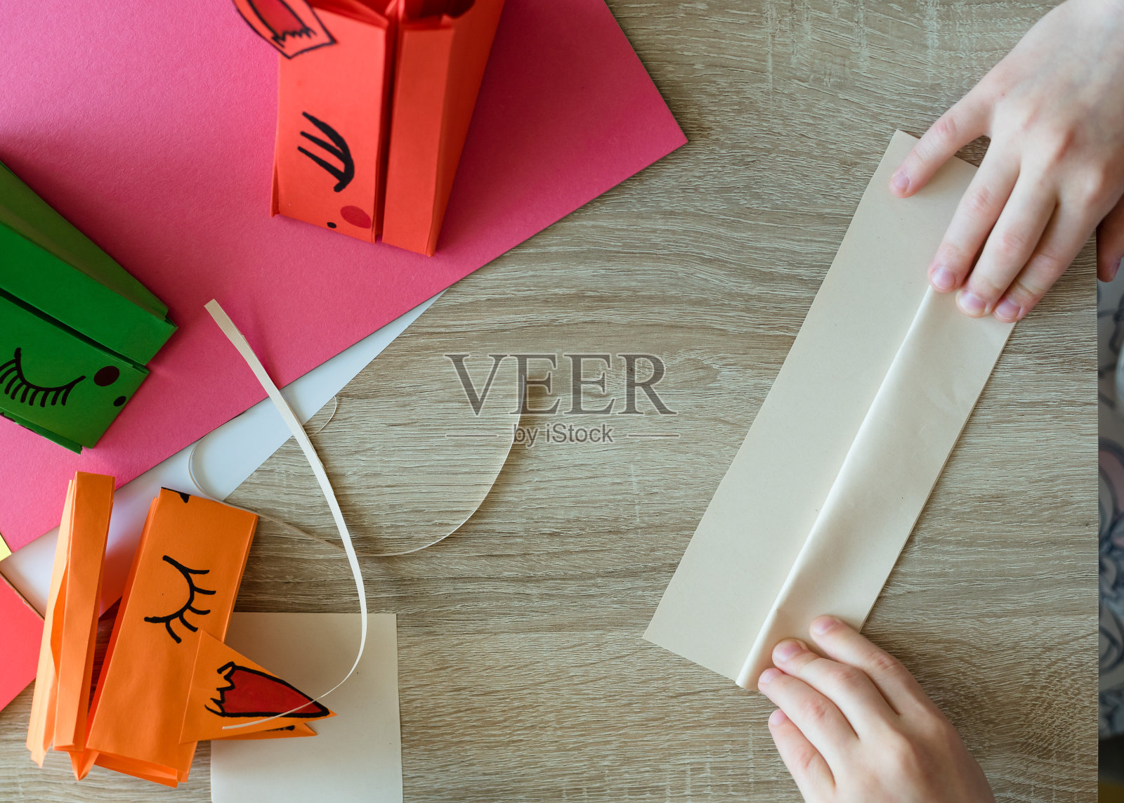 孩子们用彩纸折纸。折纸心和龙。折纸课。照片摄影图片