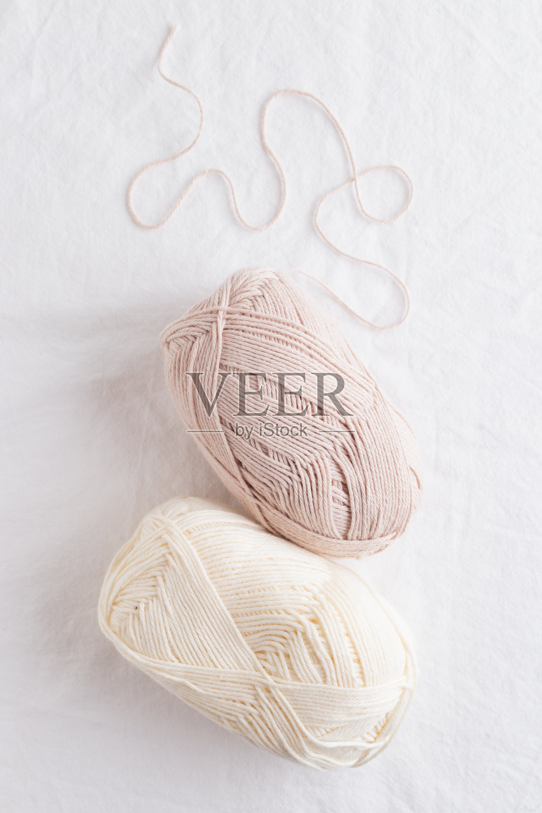 白色的桌子上放着色彩柔和的棉纱球照片摄影图片