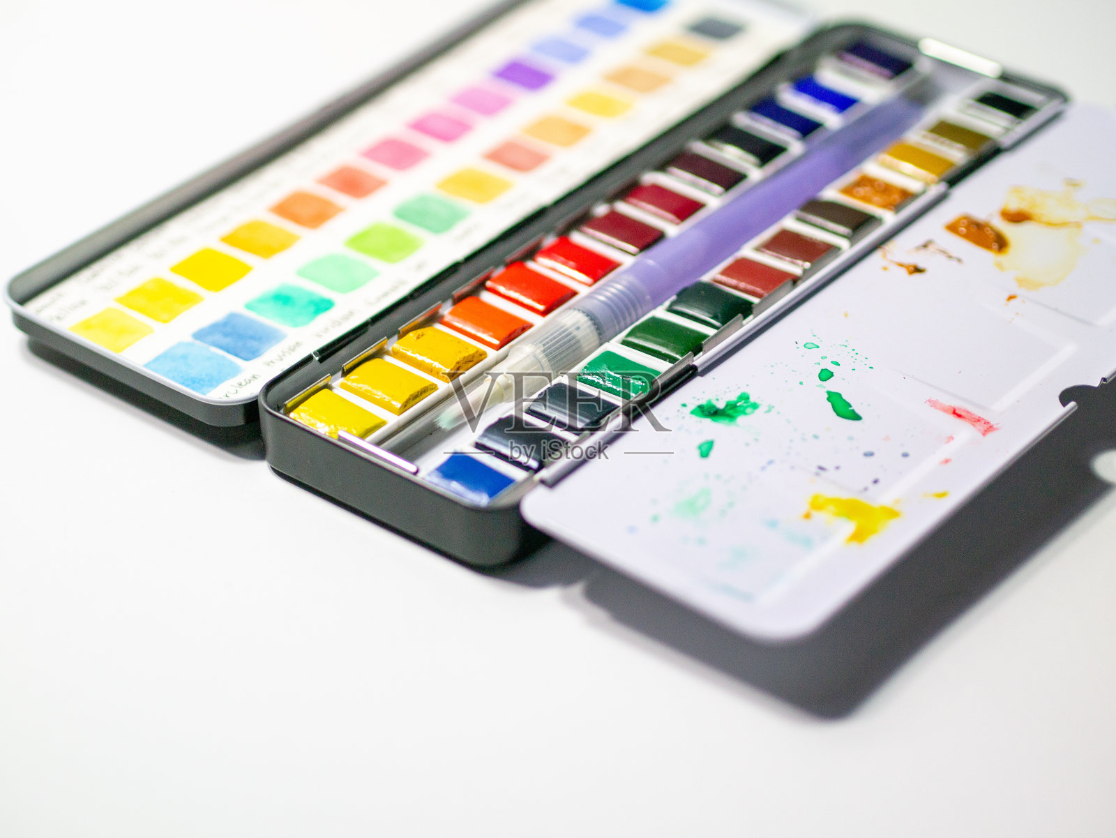 水彩锅在白色背景与颜色样本测试。照片摄影图片