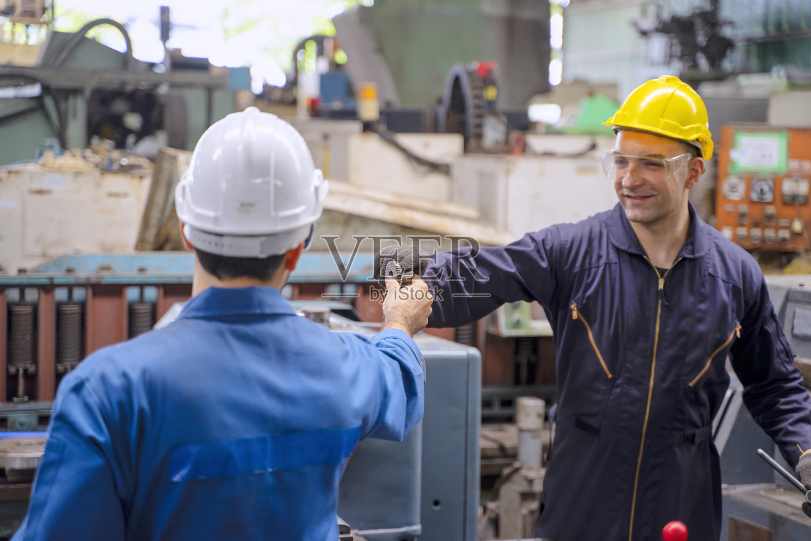 工厂里的蓝领工人和同事。照片摄影图片