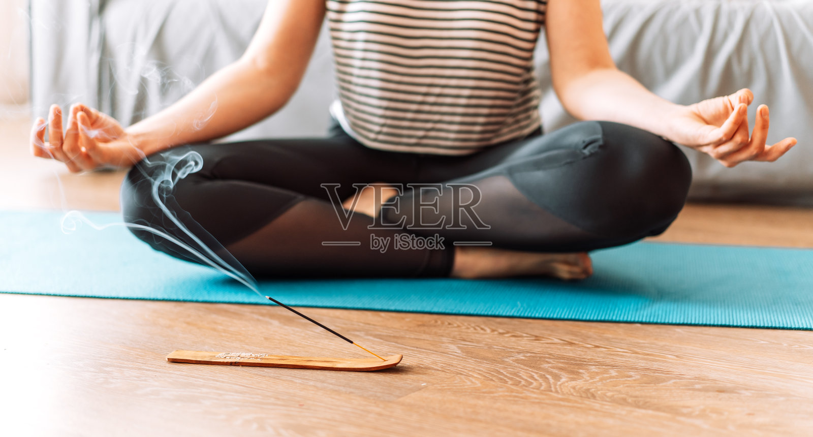 女孩在阴燃的熏香前做瑜伽照片摄影图片