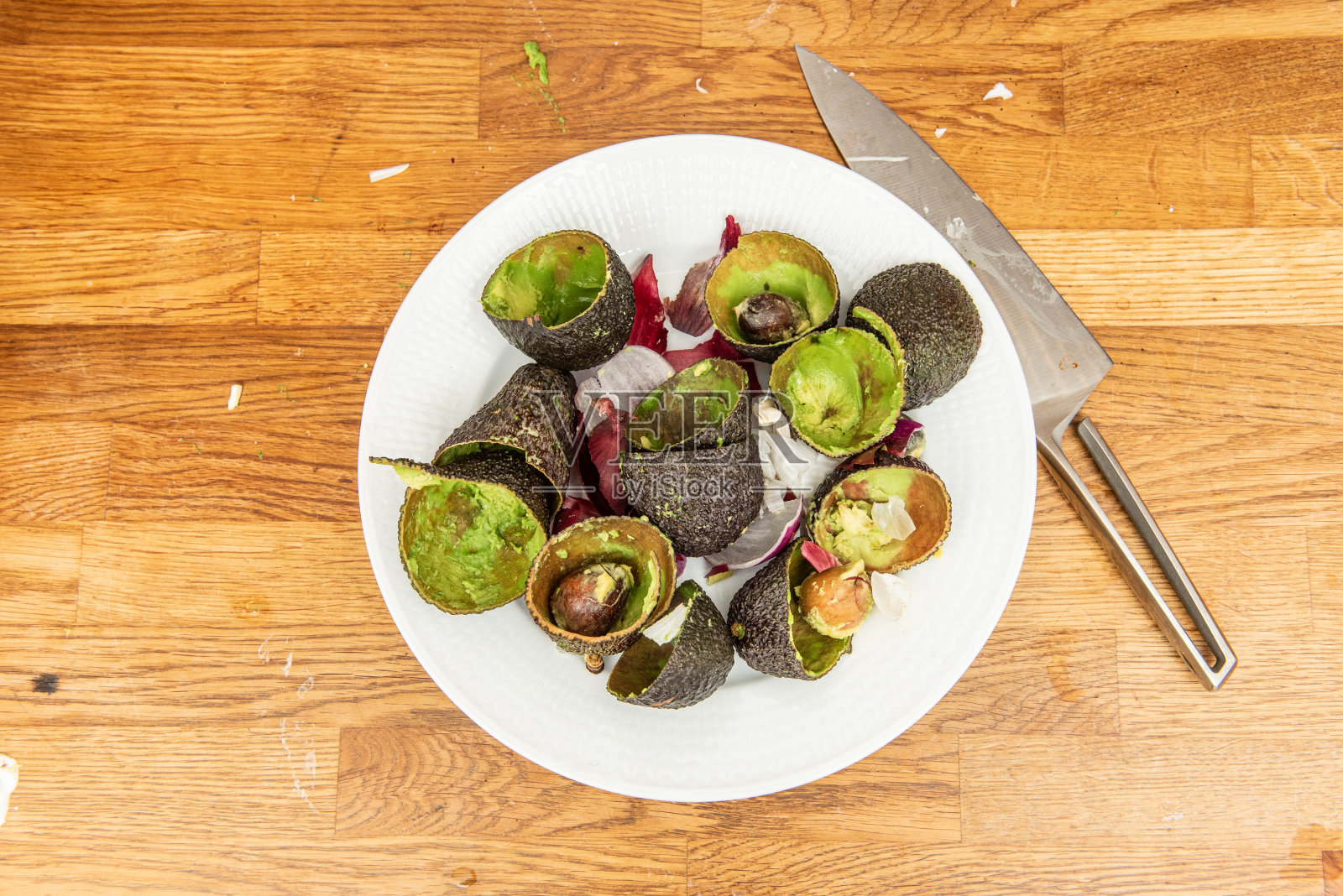 制作完美味的鳄梨色拉酱后，盘子里放着鳄梨和洋葱。照片摄影图片