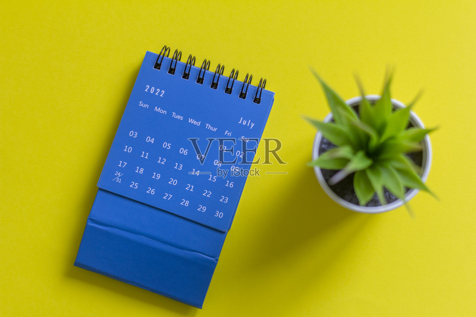 2022年7月的台历，黄色背景。照片摄影图片