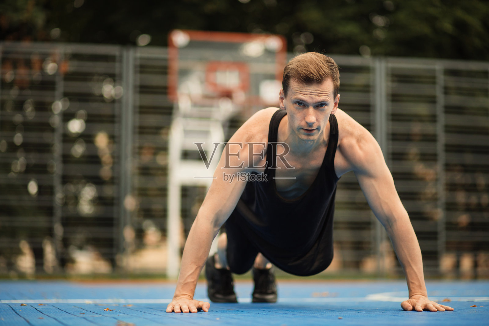 男性运动员做腹肌运动，户外运动和训练，站在平板支撑。照片摄影图片