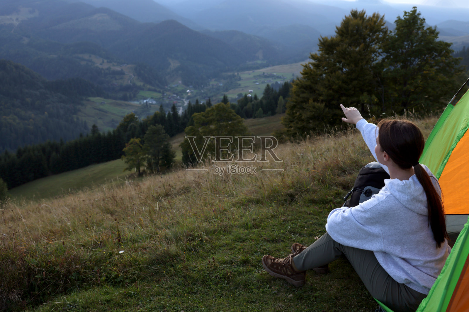 游客带着露营帐篷坐在山中的小山上照片摄影图片