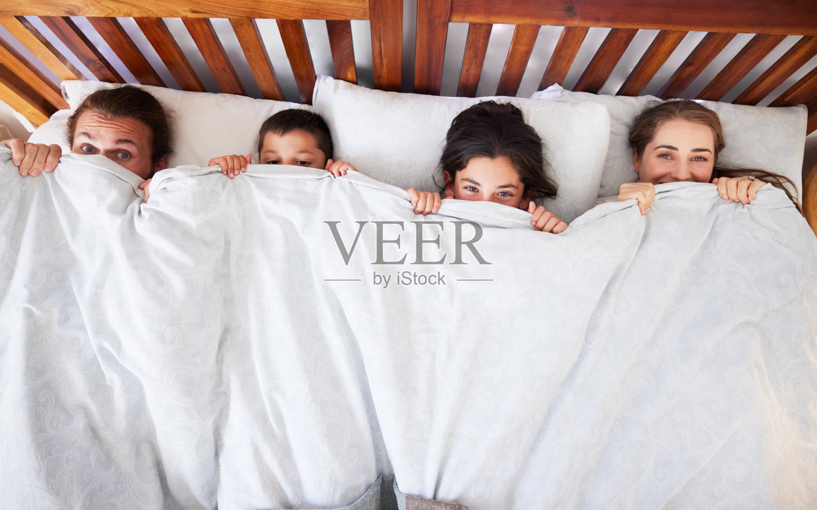 快乐的年轻白人家庭在床上享受慵懒早晨照片摄影图片