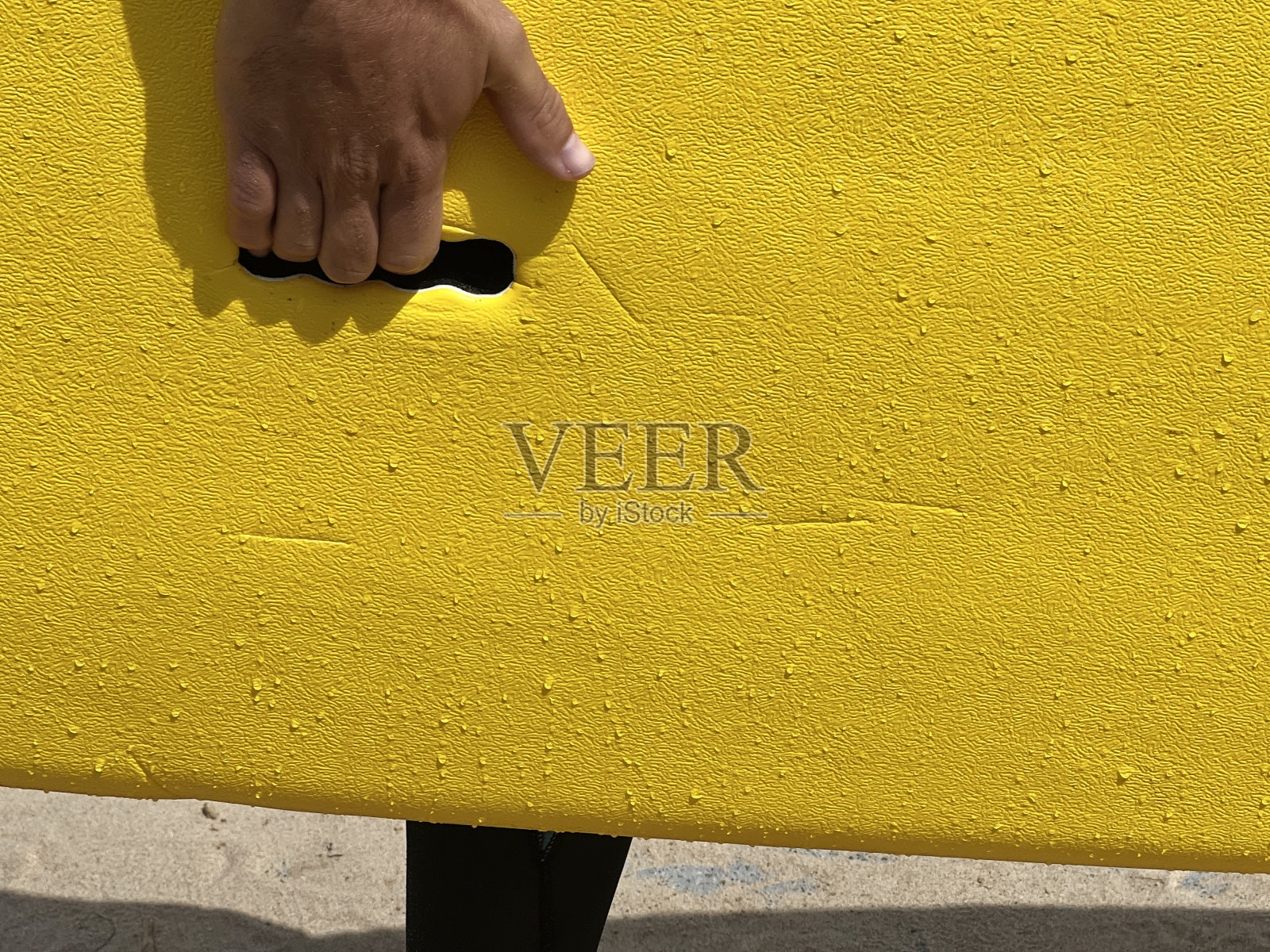 一只手拿着黄色冲浪板的细节照片摄影图片