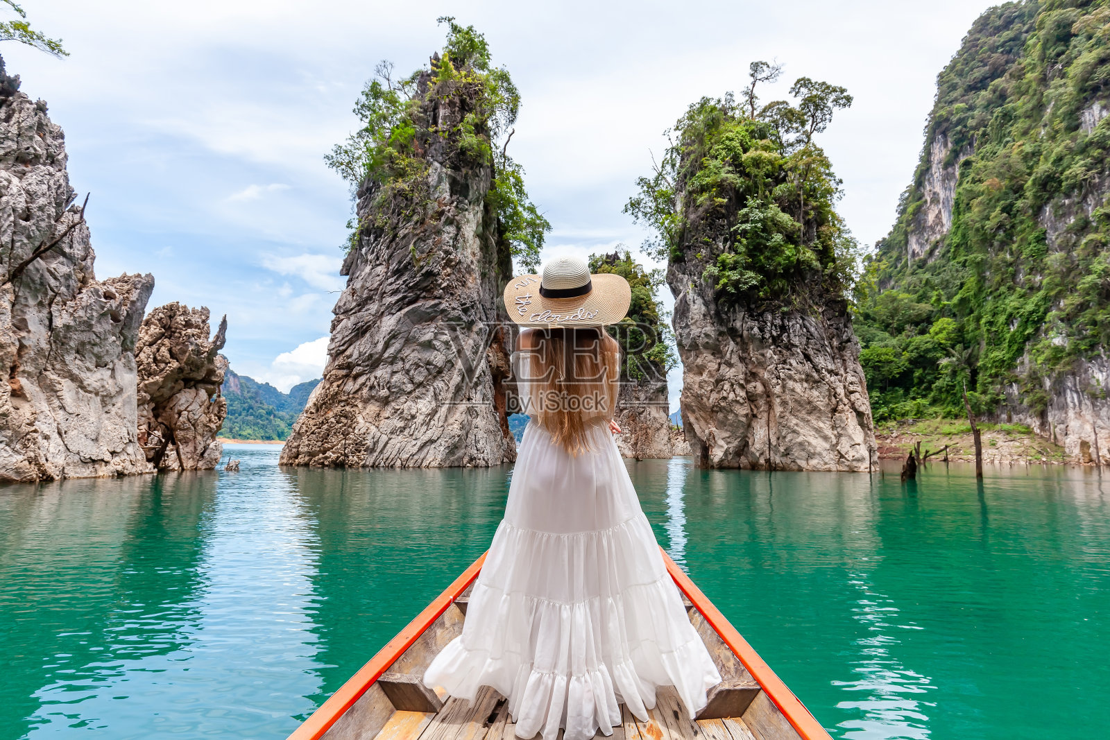戴着帽子的年轻女游客在长尾船探索蓝绿色的周兰湖照片摄影图片