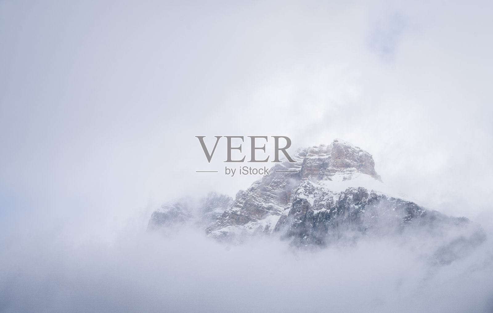 加拿大Yoho N.公园，被云雾笼罩的孤立的雪山山峰照片摄影图片