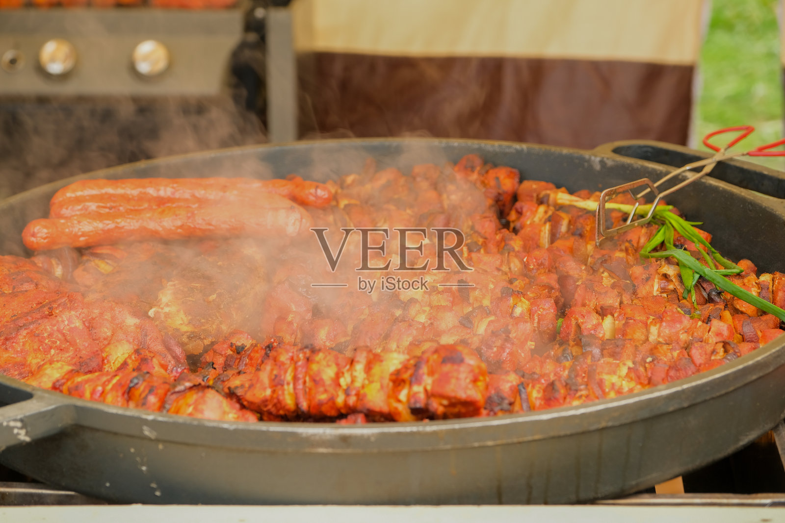 路边摊的锅里煮着美味的辣味油炸食品。街头食品。炸肉. .照片摄影图片